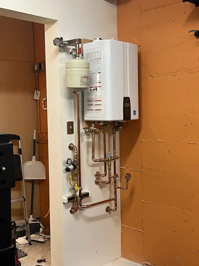 Plumbing technician inspecting water heater connections in Excelsior Springs
